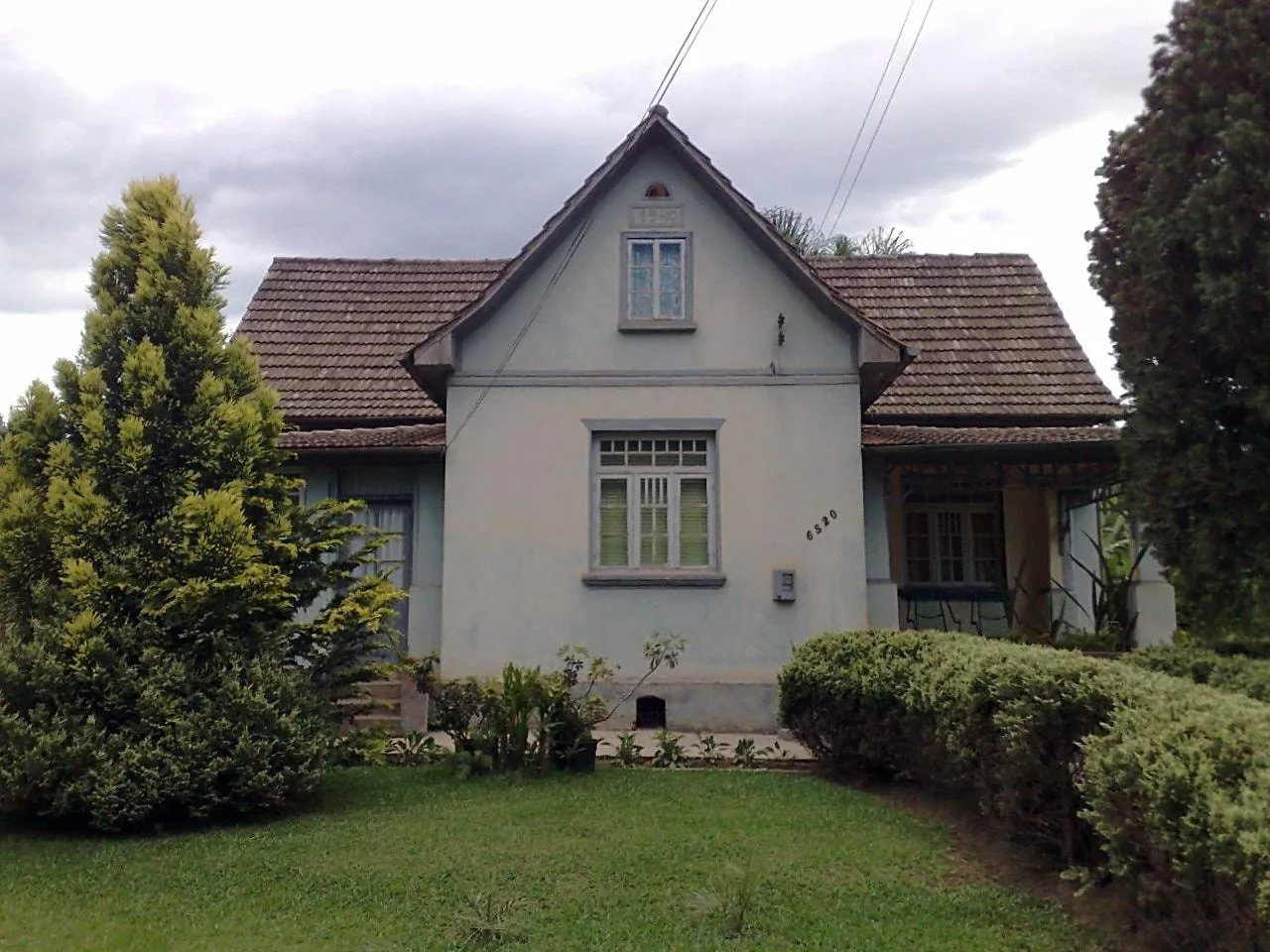 A casa da família Schiessl, de telhado alto e paredes claras, com o ano de 1940 gravado na frente do frontão